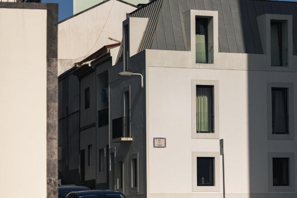 una fila de edificios blancos en una calle de la ciudad en WelcomeBuddy - Casa Rua da Fonte, en Ponta Delgada