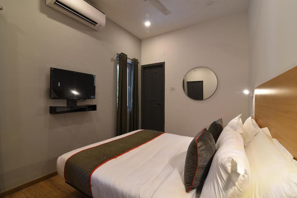 a bedroom with a bed and a flat screen tv at Townhouse Royapettah Near U.S Consulate in Chennai
