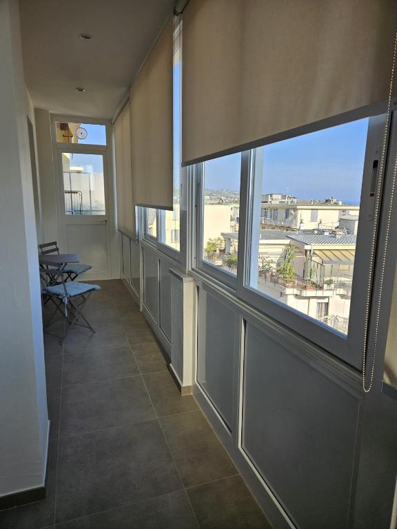 Hotel ROMA 36, an empty hallway with windows and a table and chairs at ROMA 36 in Sanremo