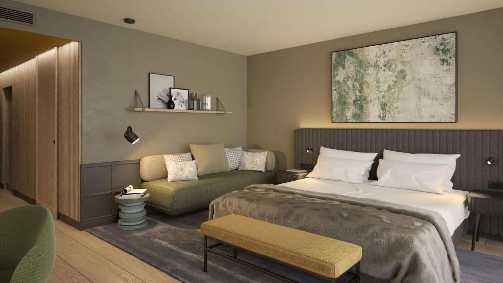 a hotel room with a bed and a couch at Grand Tirolia Kitzbühel - Member of Hommage Luxury Hotels Collection in Kitzbühel