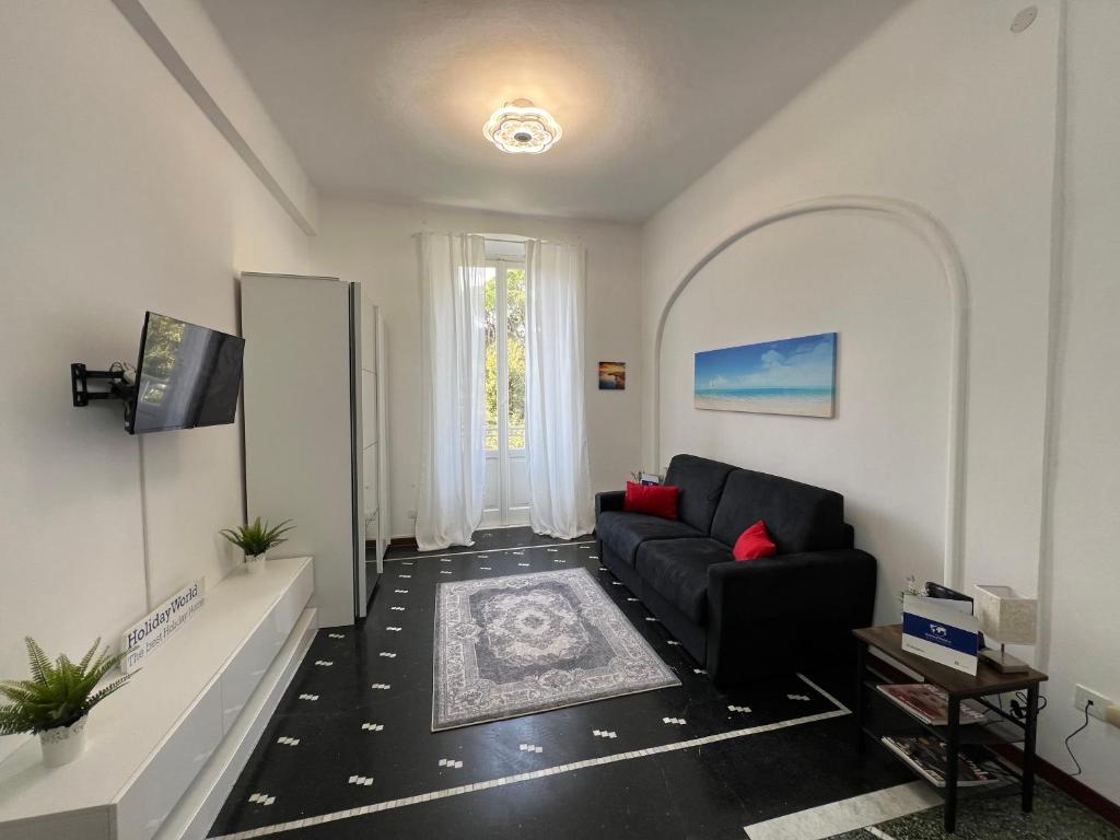 ein Wohnzimmer mit einem schwarzen Sofa und einem TV in der Unterkunft Casa Lilliana by Holiday World in Santa Margherita Ligure