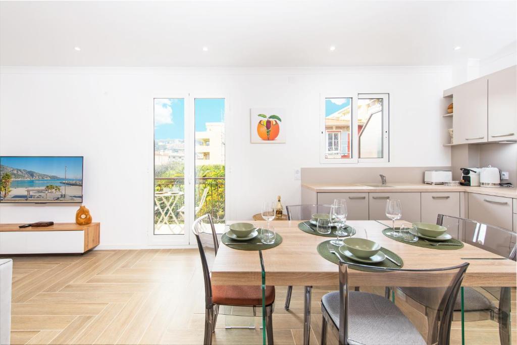 罗克布吕讷-卡普马丹ORCHIDÉES - SPLENDIDE 2 Pièces - PARKING - 50 m BORD DE MER的配有木桌椅的厨房和餐厅