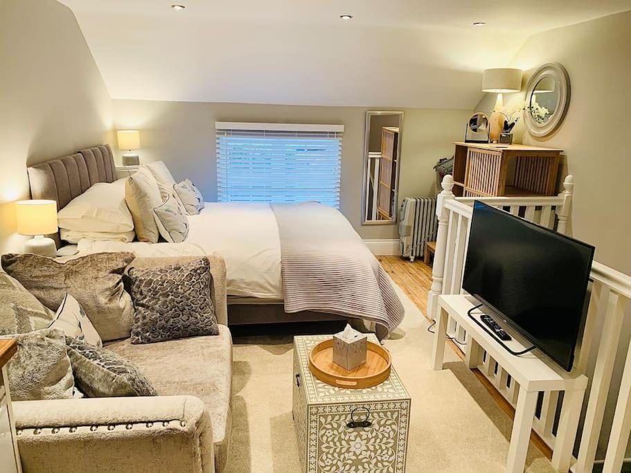 a living room with a bed and a television at The Gatehouse, Bijou studio apartment - sleeps 2 in Easingwold