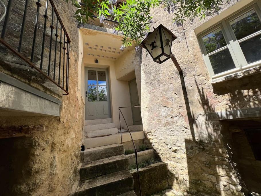 un bâtiment avec un éclairage de rue devant une porte dans l'établissement Très jolie maison de village, à Lourmarin