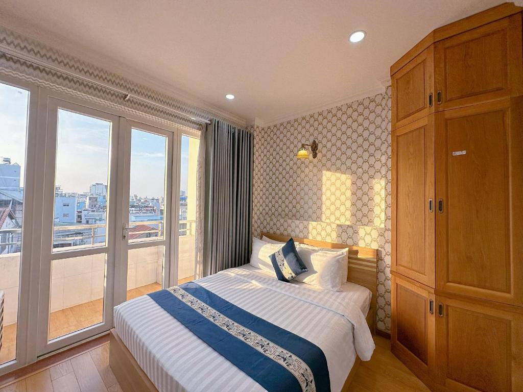 sypialnia z łóżkiem i dużym oknem w obiekcie Tra My Hotel - SaiGon Center w Ho Chi Minh