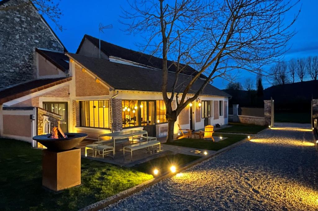 une maison avec un arbre dans la cour la nuit dans l'établissement La Petite Maison de Giverny - Gîte de charme 5 étoiles au cœur du village - 3 Chambres, à Giverny