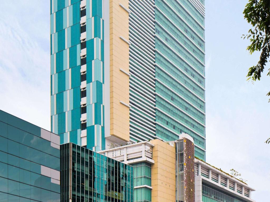 a tall building with many windows on the side of it at Novotel Jakarta Gajah Mada in Jakarta