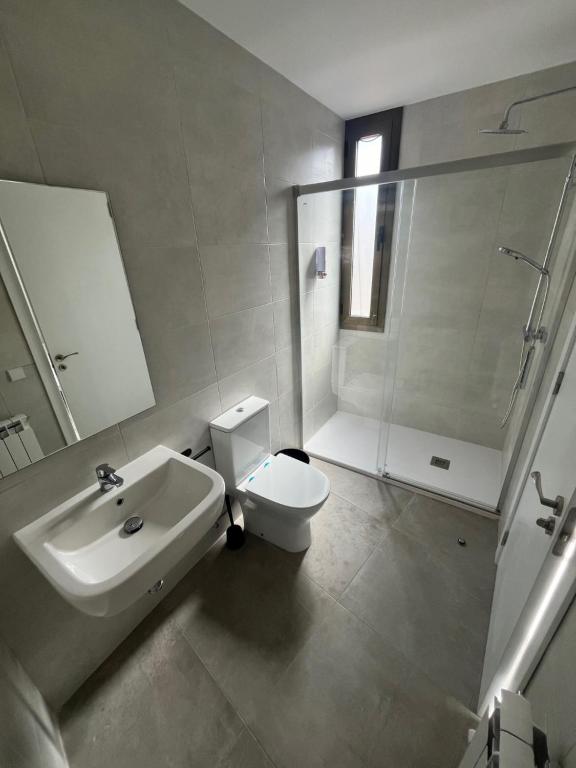 uma casa de banho com um lavatório, um WC e um chuveiro em Hostal La Masia em Manresa