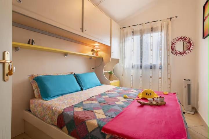 1 dormitorio con 1 cama con colcha colorida en SHR Residence Valledoria Int 25, en Codaruina