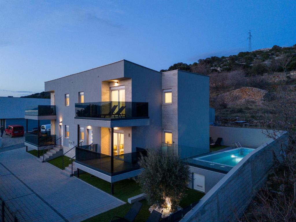 een groot huis met een zwembad ervoor bij La Vie luxury apartments with a pool in Stara Novalja