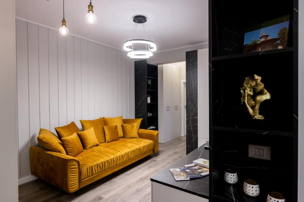 a living room with a yellow couch and a table at Prime Aparments University in Suceava