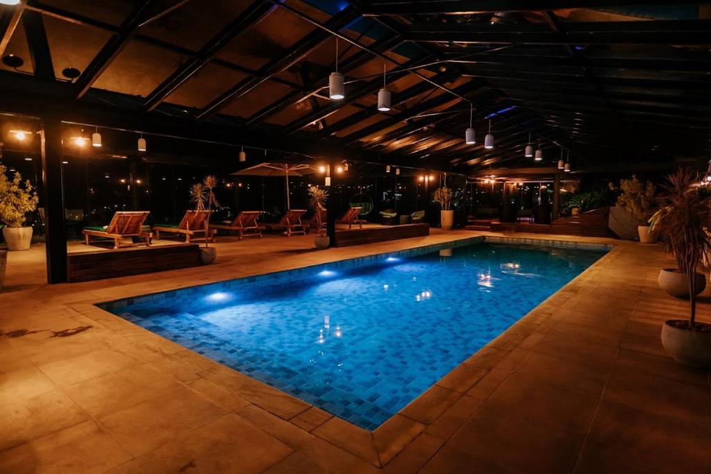 a swimming pool with blue water in a building at Chris Park Hotel in Campos do Jordão