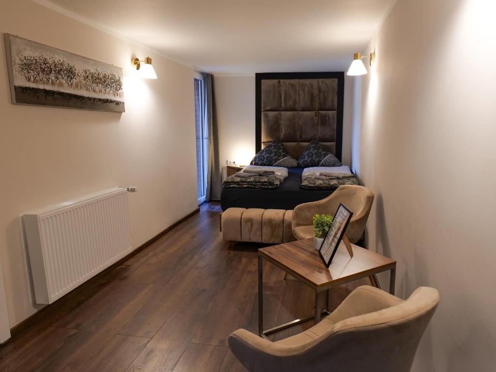sala de estar con cama, mesa y sillas en Haus Boutique en Bad Salzuflen