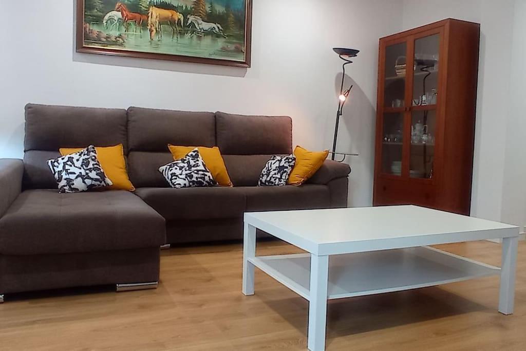 ein Wohnzimmer mit einem Sofa und einem Tisch in der Unterkunft Piso en Ourense- Sempre Maruxiña in Ourense