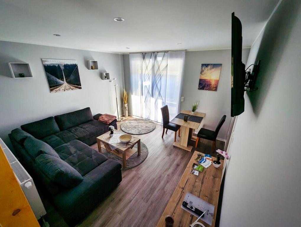 sala de estar con sofá verde y mesa en Ferienwohnung Vogt, en Blankenburg
