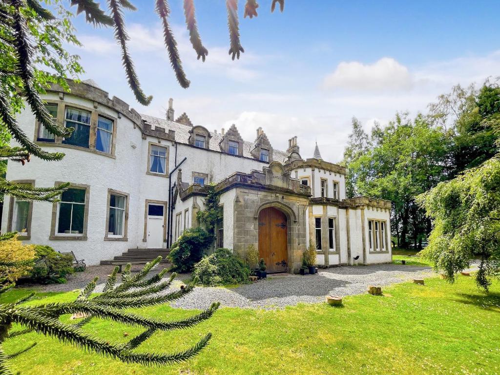 una casa antigua con un jardín delante de ella en Harvieston Hall en Gorebridge