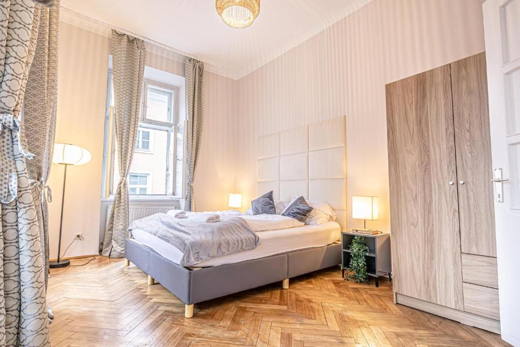 a bedroom with a bed and a large window at Metropolitan Charm: Stylish 2+1 Apt@ Vienna's Core in Vienna
