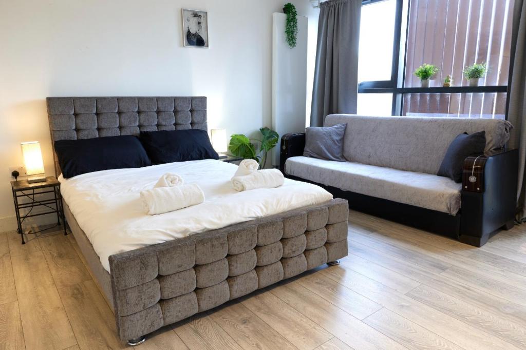 a bedroom with a large bed and a couch at Wonderful Holiday Studio in the Trendy Brick Lane in London