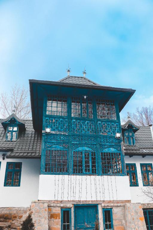 a building with blue windows and a roof at Casa Plaiul Cailor: Rustic Mountain Hideaway in Proviţa de Sus