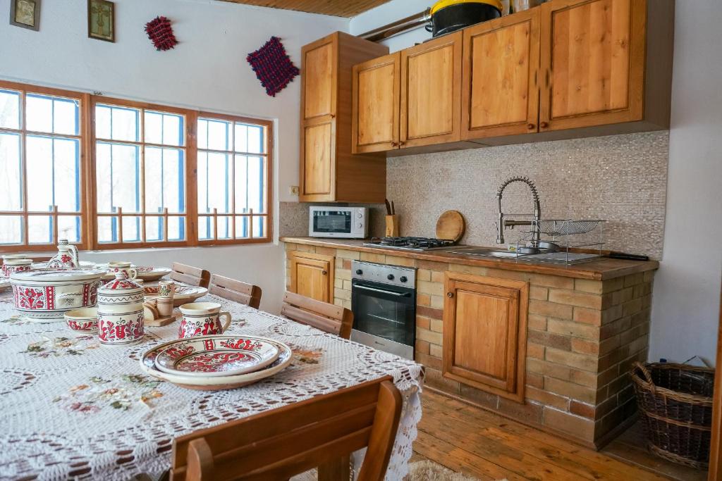 eine Küche mit einem Tisch und Geschirr darauf in der Unterkunft Casa Plaiul Cailor: Rustic Mountain Hideaway in Proviţa de Sus