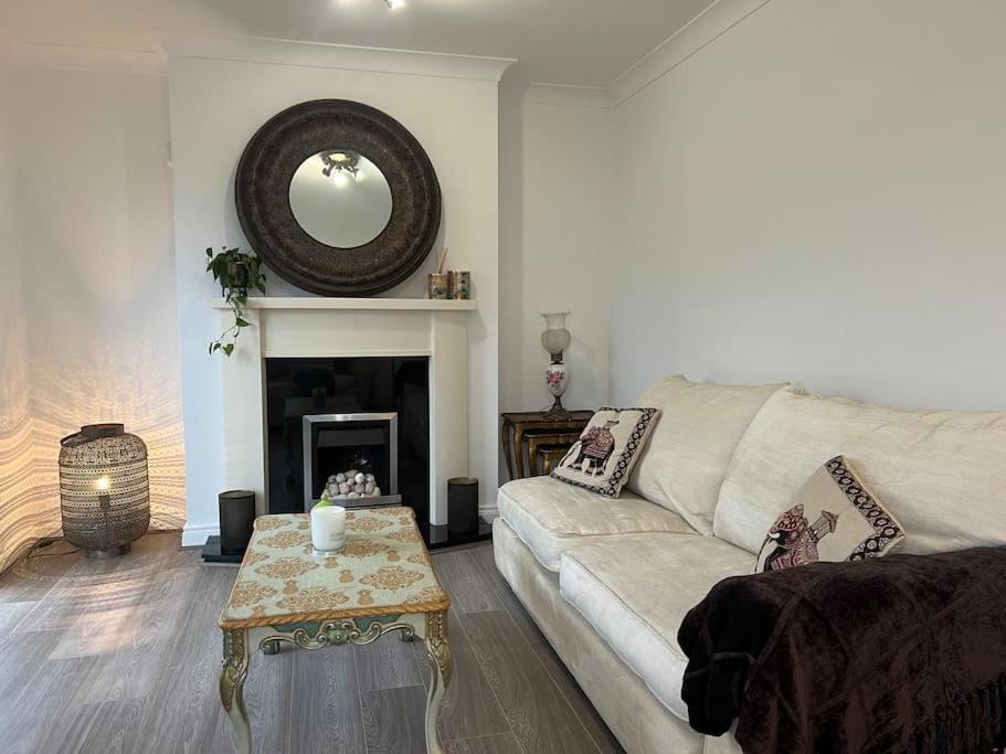 a living room with a white couch and a fireplace at Cosy 2 Double Bed Apartment in Swords