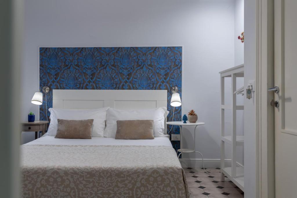 1 dormitorio con 1 cama grande y cabecero azul en Viva Catania, en Catania