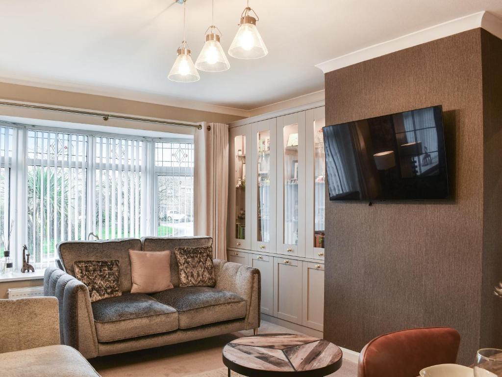 a living room with a couch and a tv at Shirleys Place in Boston Spa