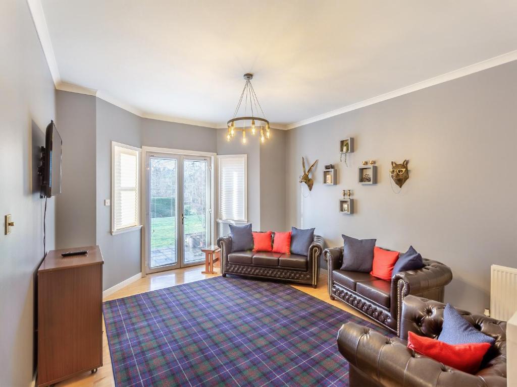 a living room with two couches and a tv at Bluegrass Retreat On The River Ness in Inverness