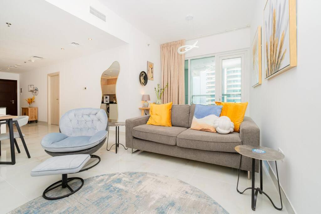 a living room with a couch and a chair at Dubai Marina - 1BHK Apartment in Dubai