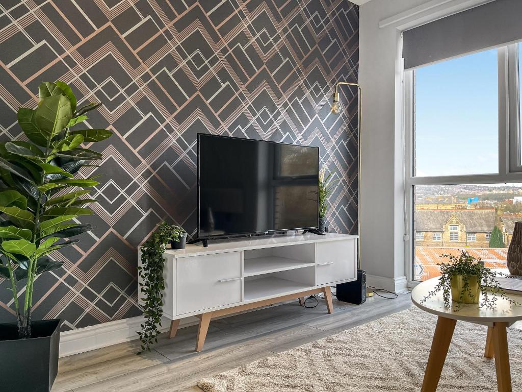 a living room with a flat screen tv on a wall at Apartment 205 in Sheffield