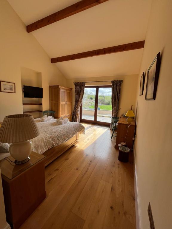 ein Schlafzimmer mit einem Bett und einem großen Fenster in der Unterkunft Neuadd Villa in Llanwnen
