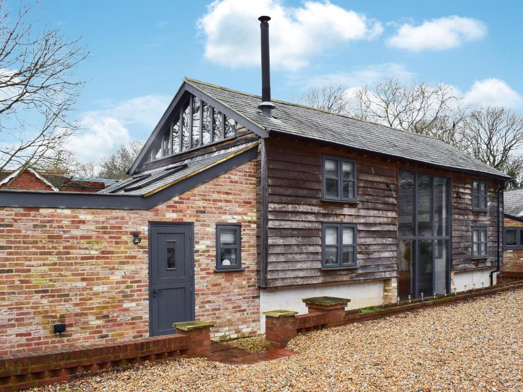 uma velha casa de tijolos com uma porta azul em Uk46591 - Polecat Barn em Wivelsfield Green