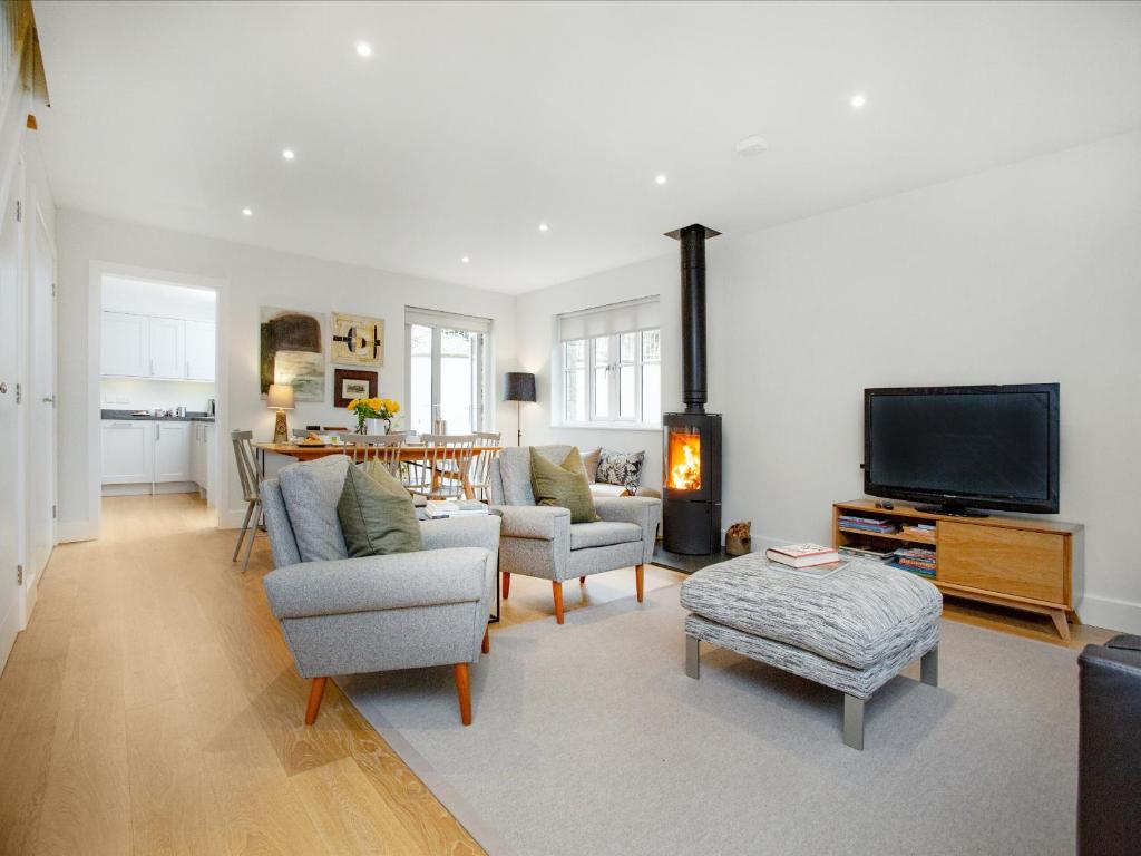 a living room with couches and a tv and a table at Myrtle House in Pendeen