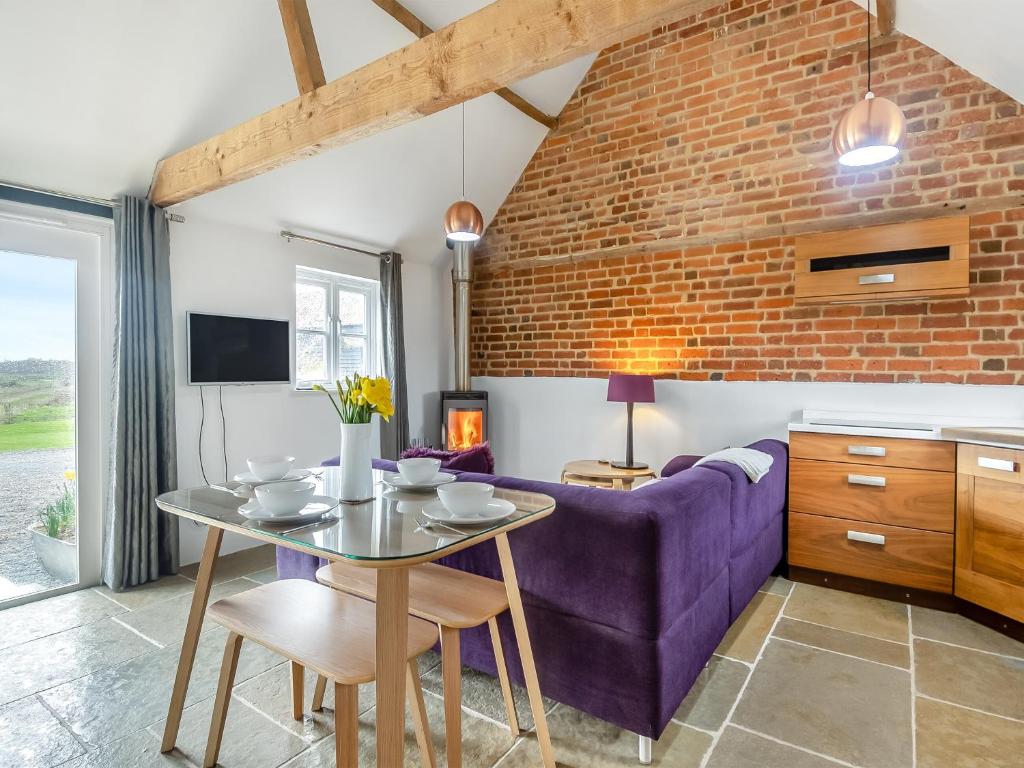 - un salon avec un canapé violet et une table dans l'établissement Waveney Valley View, à Burgh Saint Peter
