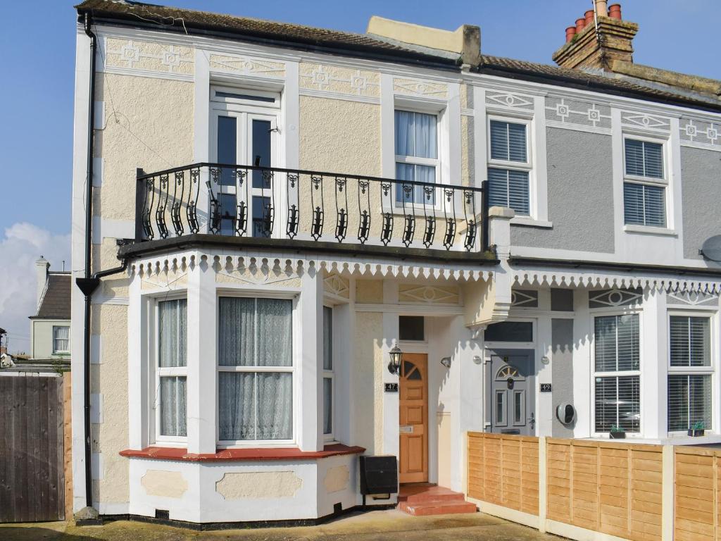 a white house with a balcony on top of it at Avondale in Clacton-on-Sea