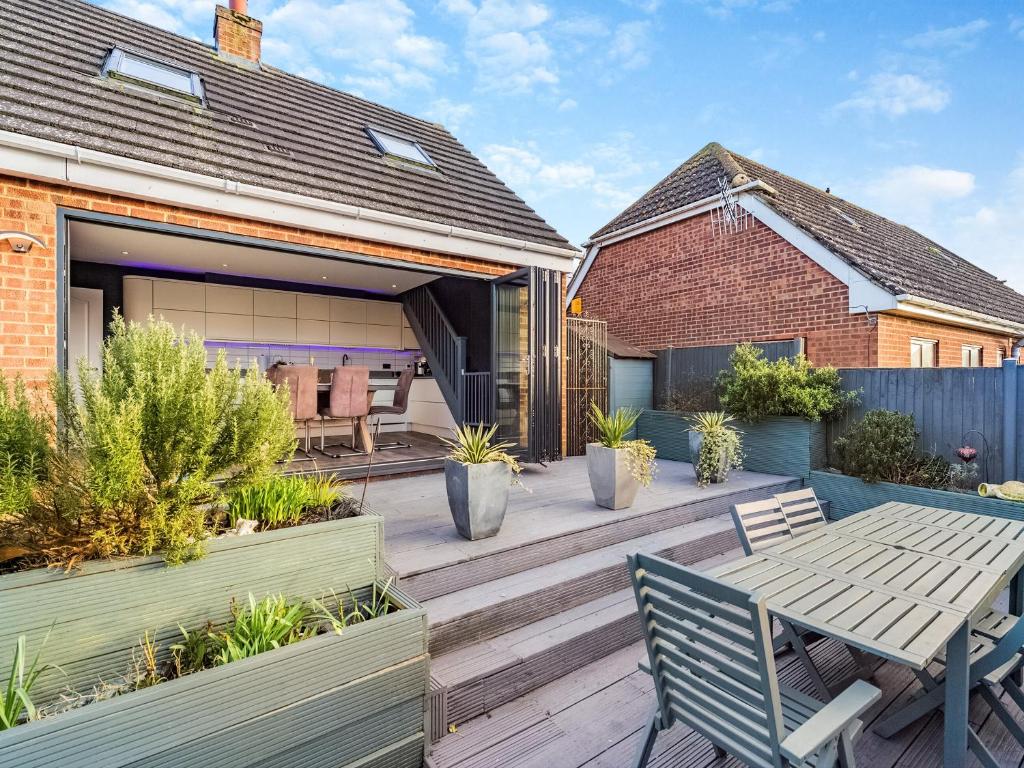 una terraza de madera con mesa y sillas en una casa en Silvaplana, en Canterbury