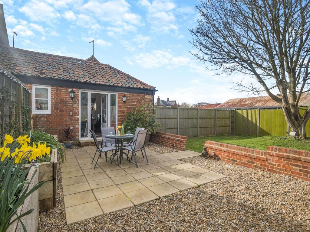 a patio with a table and chairs in front of a house at The Barn in Martham