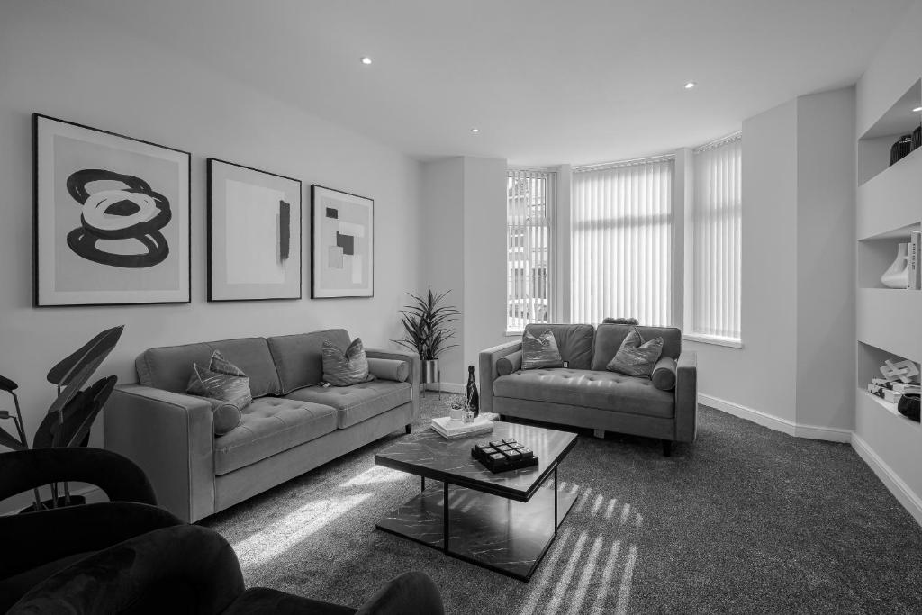 a living room with two couches and a coffee table at The 1878 by STAMP SA in Blackpool