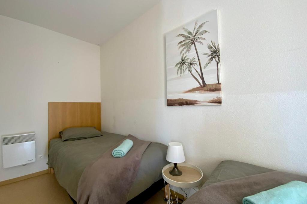 - une chambre avec 2 lits et une photo de palmiers dans l'établissement C10 Les Naïades- 2 bedrooms for 6 people !, à Avène
