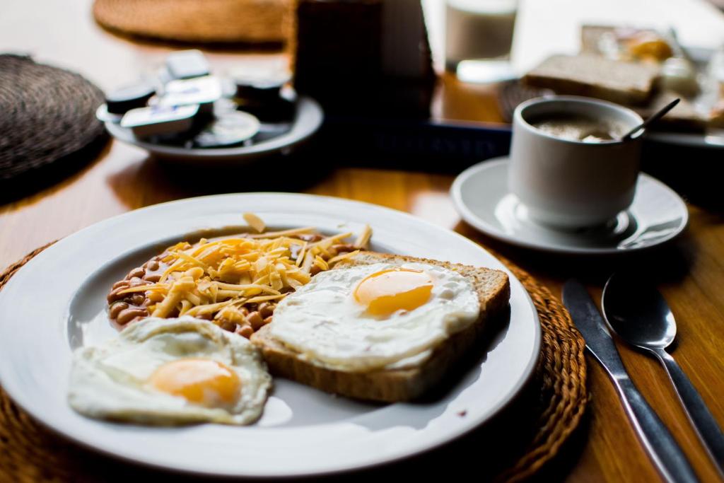 a plate of food with eggs and toast on a table at Frankstay By Hotel SAMRAT RESIDENCY 10 Mints Walking Distance Nizamuddin Railway Station in New Delhi