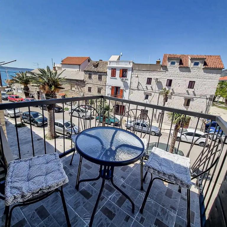 eine Terrasse mit einem Tisch und Stühlen auf dem Balkon in der Unterkunft Holiday Home Old Art in Kaštela