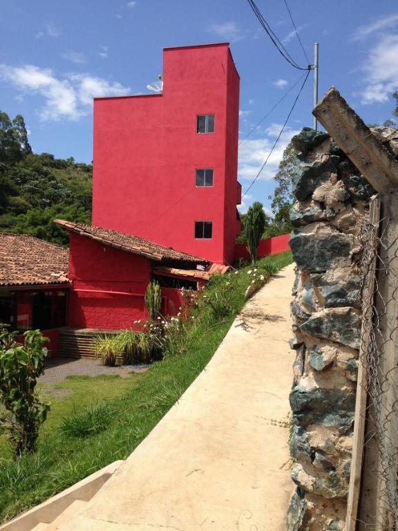 サンタ・バルバラにあるPousada Maria Franciscaの道路横の石垣赤い建物
