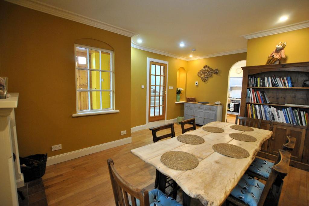 a dining room with a table and a book shelf at The House on the Square- Coastal Townhouse in Saint Monance