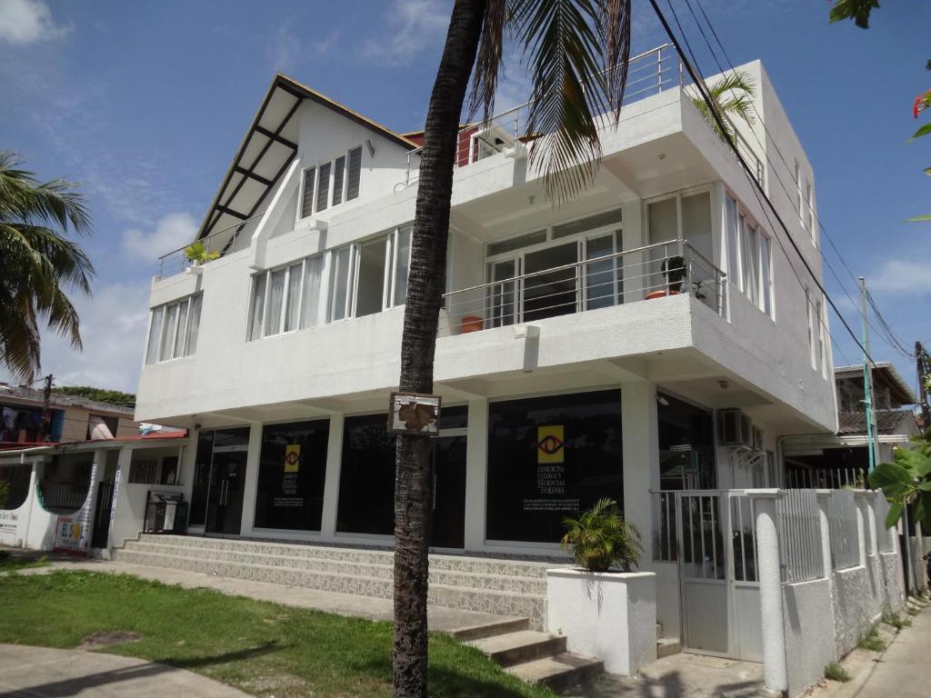 un bâtiment blanc avec un palmier en face dans l'établissement Lili House, à San Andrés