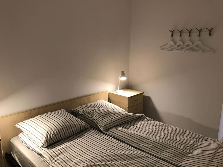 um quarto com uma cama e uma mesa de cabeceira com um candeeiro em Holiday rental in Roquebrune Cap Martin em Roquebrune-Cap-Martin