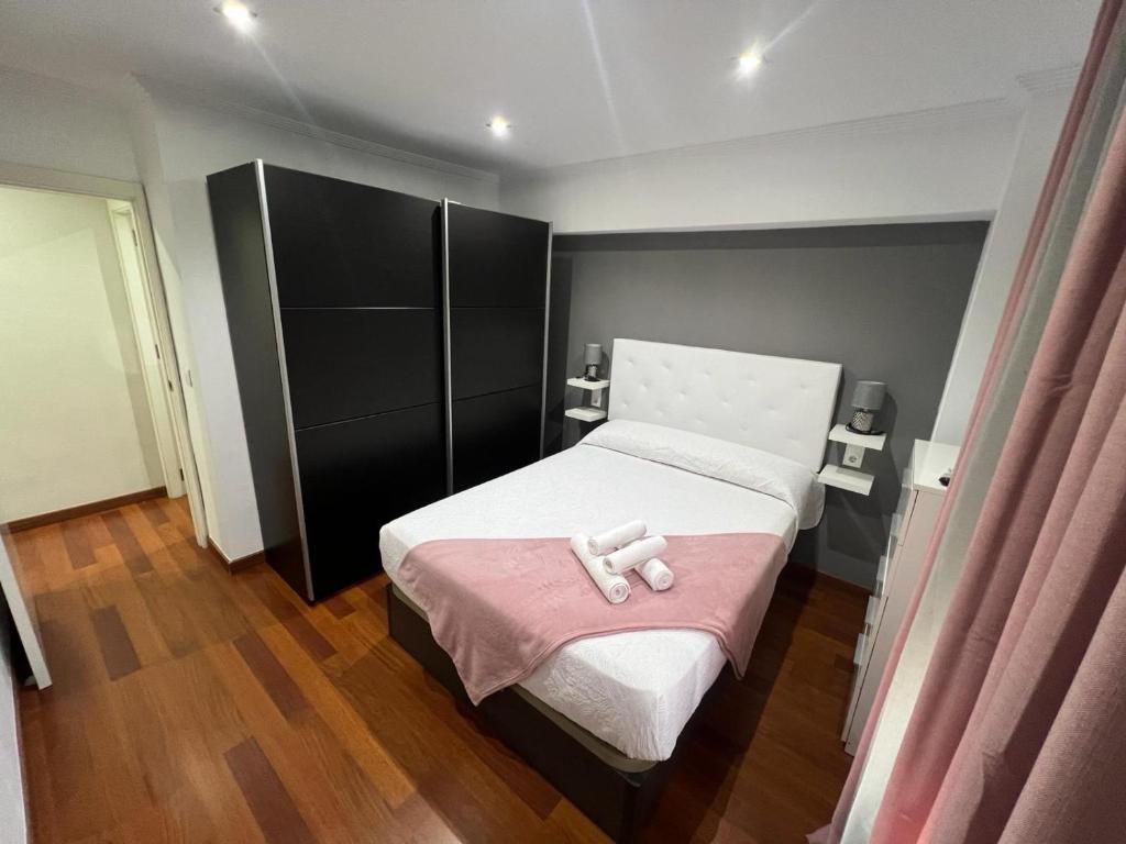 a small bedroom with a bed with a pink blanket at Magnífico alojamiento cerca de, Mezquita catedral in Córdoba