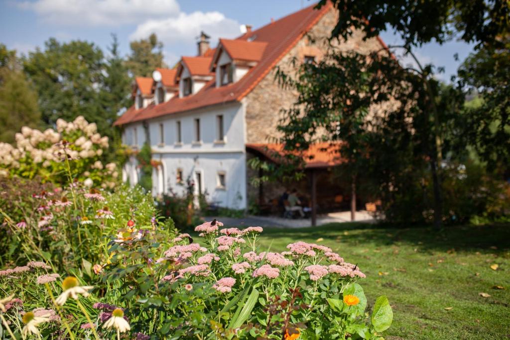 ein großes weißes Haus mit einem Hof mit Blumen in der Unterkunft Villa Greta in Schönau an der Katzbach