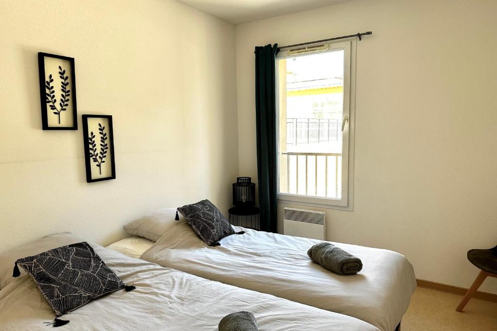 deux lits dans une chambre avec une fenêtre dans l'établissement Les Naïades E19 - 2 bedrooms for 5 people !, à Avène