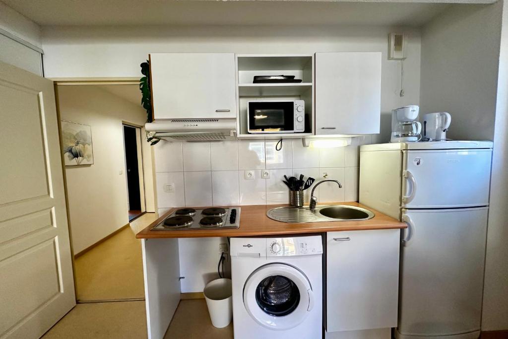 a small kitchen with a washing machine and a washer at E20 Les Naïades- 2 bedrooms for 5 people ! in Avène