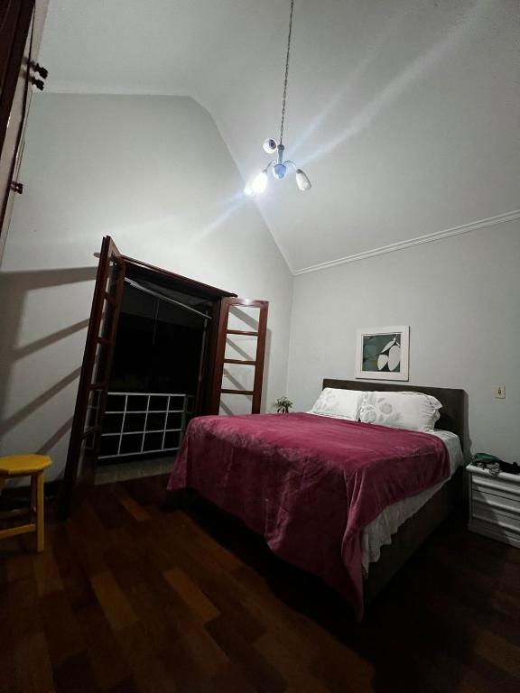 um quarto com uma cama com um cobertor vermelho em Excelente quarto em Alphaville em Santana de Parnaíba